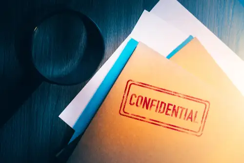 Desk of Private Detective With Confidential Information Folder