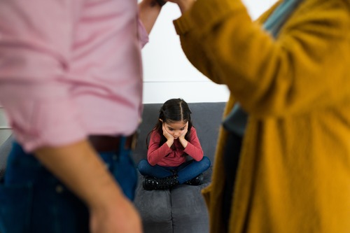 Child on Couch with Arguing Parents