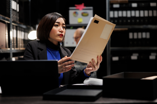 Female Investigator Looking at Files - Need a Private Investigator