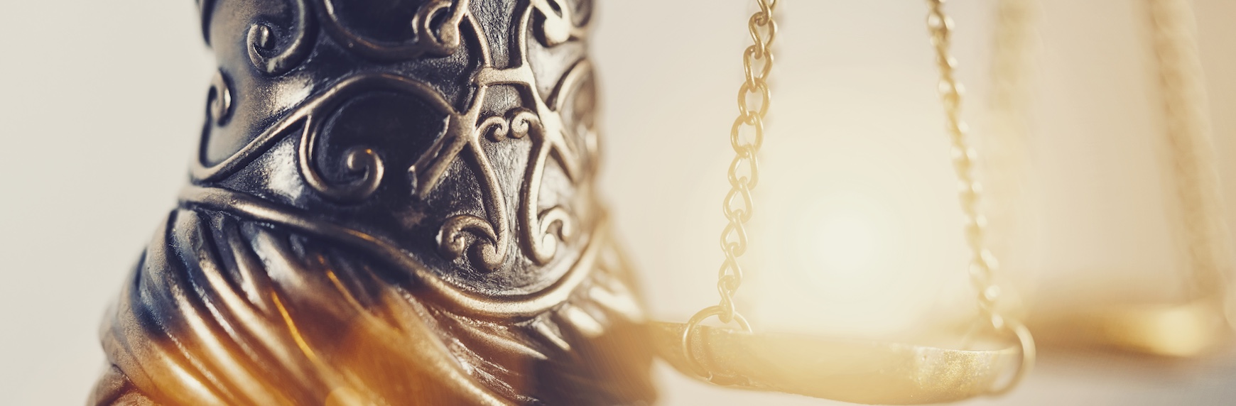 Close-up of ornate decorative justice scales symbolizing civil litigation, legal proceedings, and the courtroom balance of evidence.