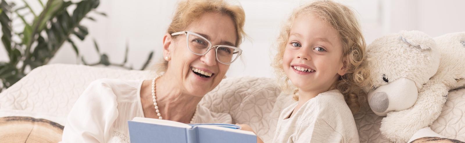 A nanny and child are enjoying reading time together after completing nanny and caregiver background checks for trusted childcare services.