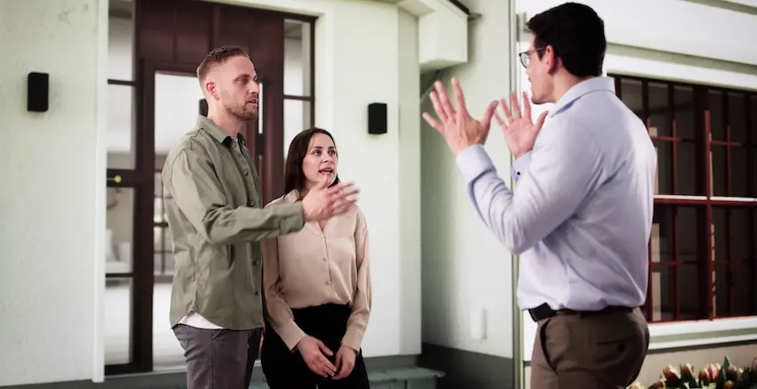 A couple gestures and speaks firmly to another man outside a residential property in what appears to be a heated confrontation illustrating the type of neighbor disagreements that can escalate into HOA disputes requiring legal intervention from Upstate Private Investigators.