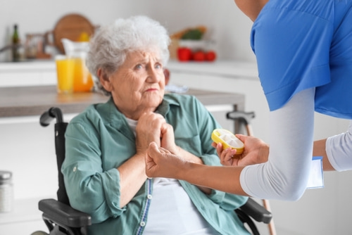 Nursing home abuse and neglect concept, elderly woman afraid of angry nurse