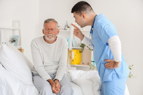 Nursing home neglect and abuse concept, senior man scared of angry nurse