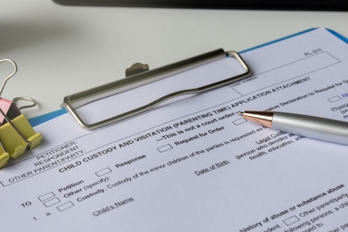 A pen on top of a child custody form represents a child custody investigator helping a client get visitation rights.