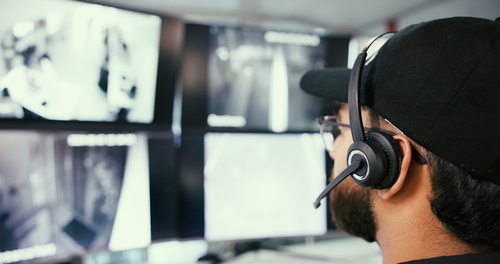A private investigator looking at screens represents surveillance services being provided for a client.