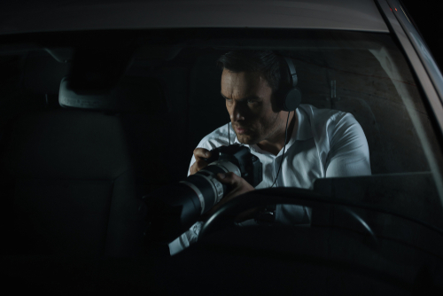 An adultery investigator with a headset and a camera to get evidence at night.